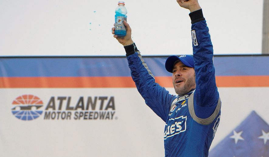 Jimmie Johnson celebrates after winning the NASCAR Sprint Cup race at Atlanta Motor Speedway on Sunday. (Associated Press)