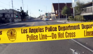 Police crime scene tape is stretched across a street in South Central Los Angeles. (Associated Press) **FILE**
