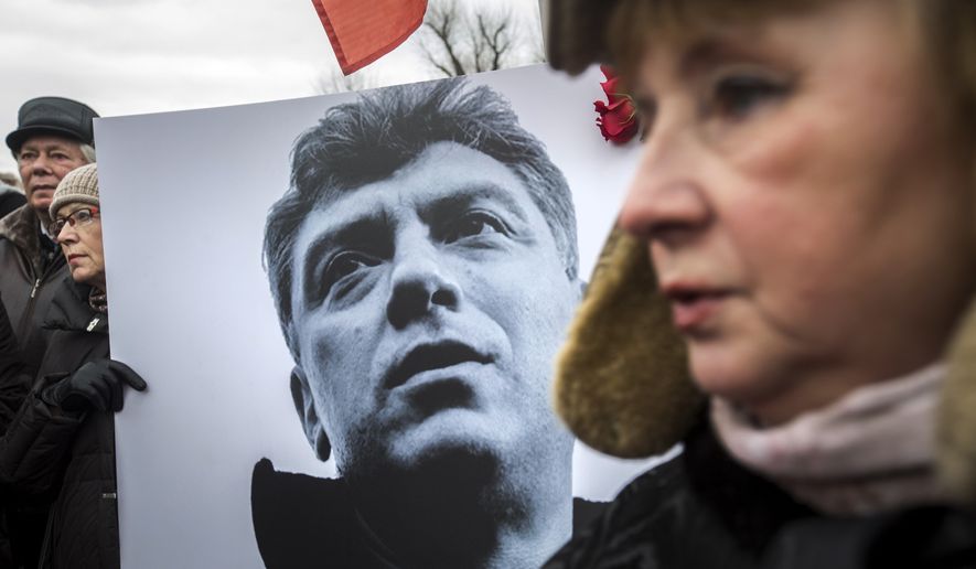 People carry a placard with the image of opposition leader Boris Nemtsov who was gunned down on Friday, during a march, in St. Petersburg, Russia, Sunday, March 1, 2015. (AP Photo/Elena Ignatyeva)