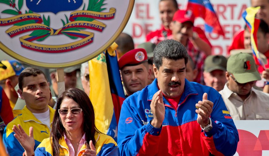 Venezuela&#39;s President Nicolas Maduro, right, and his wife Cilia Flores greet supporters during a rally outside of Miraflores presidential palace in Caracas, Venezuela, Saturday, Feb. 28, 2015. Venezuelans took to the streets of Caracas in dueling demonstrations on Saturday, with one group calling attention to a crackdown on opponents of the government and another showing support for the embattled socialist administration. T (AP Photo/Fernando Llano)