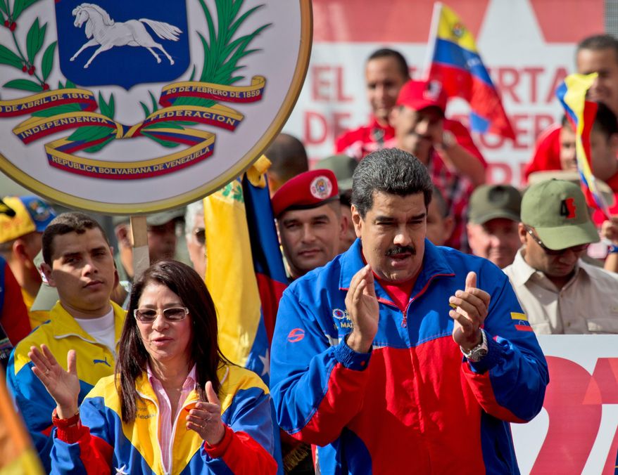 Venezuela&#x27;s President Nicolas Maduro, right, and his wife Cilia Flores greet supporters during a rally outside of Miraflores presidential palace in Caracas, Venezuela, Saturday, Feb. 28, 2015. Venezuelans took to the streets of Caracas in dueling demonstrations on Saturday, with one group calling attention to a crackdown on opponents of the government and another showing support for the embattled socialist administration. T (AP Photo/Fernando Llano)
