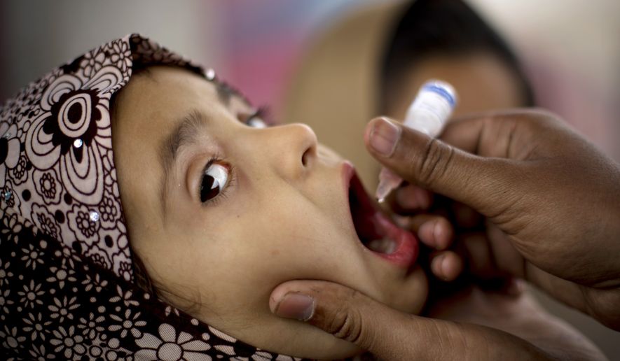 A Pakistani health worker gives polio vaccine to a child at a bus terminal in Rawalpindi, Pakistan, on Feb. 16, 2015. While vaccine distrust has sparked debates amid a measles outbreak in the United States, Pakistan is in a deadly battle to wipe out polio. Long eradicated in the West, polio remains endemic in Pakistan after the Taliban banned vaccinations, attacks targeted medical staffers and suspicions lingered about the inoculations. (Associated Press)