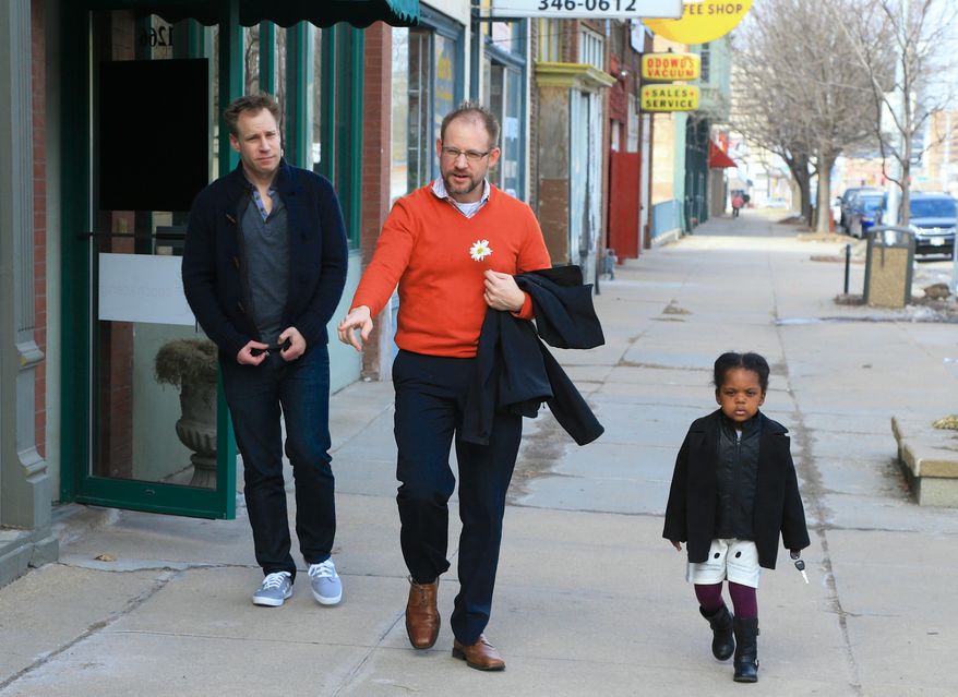 Nick Kramer, left, Jason Cadek and their 3-year-old daughter Alice leave a news conference in Omaha, Neb., Monday, March 2, 2015, convened after a federal judge blocked Nebraska's man-woman marriage law from being enforced. The men are one of seven same-sex couples who filed a lawsuit in 2014 challenging the state's voter-backed law, which doesn't recognize same-sex unions. Mr. Kramer, said he wants the ban to be overturned to give Mr. Cadek automatic custody rights for his adopted daughter. The men married in Iowa in 2013. The Nebraska attorney general's office said it will appeal any decision blocking or overturning the marriage law. (AP Photo/Nati Harnik/File)