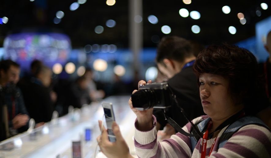 A person takes a picture of the new devices at the Mobile World Congress, the world's largest mobile phone trade show in Barcelona, Spain, Monday, March 2, 2015. (AP Photo/Manu Fernandez)