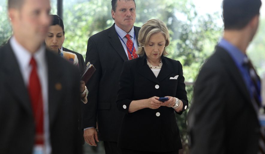 Secretary of State Hillary Rodham Clinton checks her phone after attending a U.S.-Russia meeting in Hanoi, Vietnam on July 23, 2010. The revelation that Mrs. Clinton used an off-the-books email account during her time as secretary of state has raised fresh questions about her credibility heading into 2016. (Associated Press)