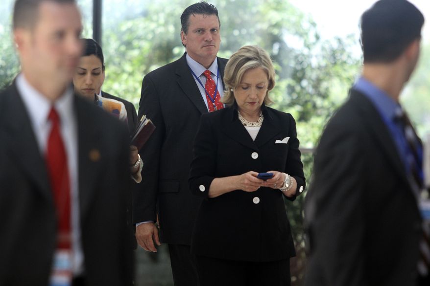 Secretary of State Hillary Rodham Clinton checks her phone after attending a U.S.-Russia meeting in Hanoi, Vietnam on July 23, 2010. The revelation that Mrs. Clinton used an off-the-books email account during her time as secretary of state has raised fresh questions about her credibility heading into 2016. (Associated Press)