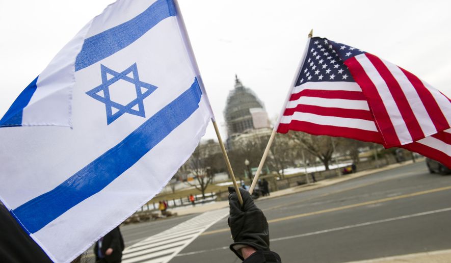 A pro-Israel demonstrator waves flags toward the U.S. Capitol in Washington, Tuesday, March 3, 2015. (AP Photo/Cliff Owen)