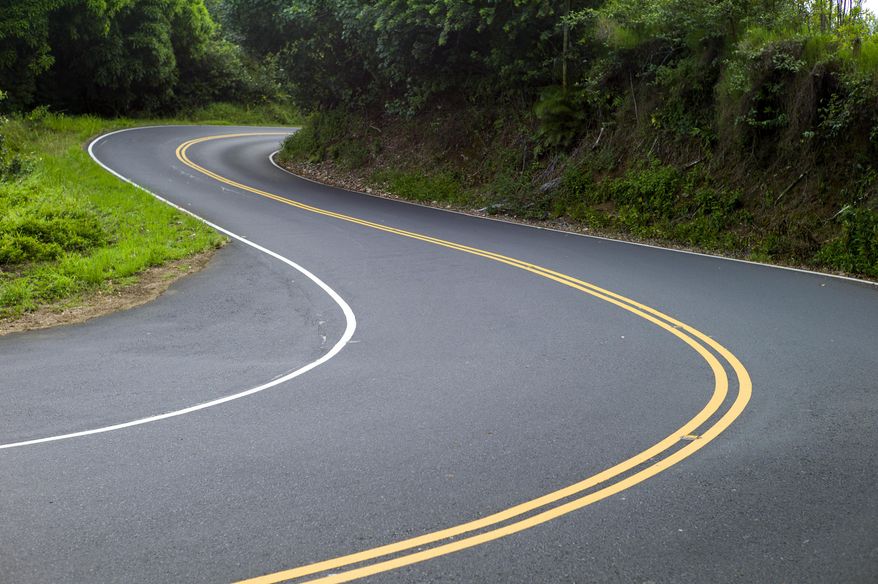 This Sept. 24, 2014 photo shows the curvy Hana Highway in Hana, Hawaii. The road cuts through Maui’s valleys and mountains and slithers above its coastal shores. (AP Photo/Marco Garcia)