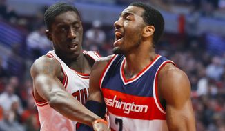 Washington Wizards guard John Wall (2) is fouled on the way to the basket by Chicago Bulls forward Tony Snell during the first half of an NBA basketball game, Tuesday, March 3, 2015, in Chicago. (AP Photo/Kamil Krzaczynski)