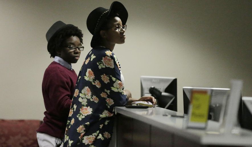 In this Feb. 9, 2015, file photo, Shanté Wolfe, left, and Tori Sisson, right, wait for their marriage license to be processed before becoming the first couple to file their marriage license in Montgomery, Ala. (AP Photo/Brynn Anderson, file)