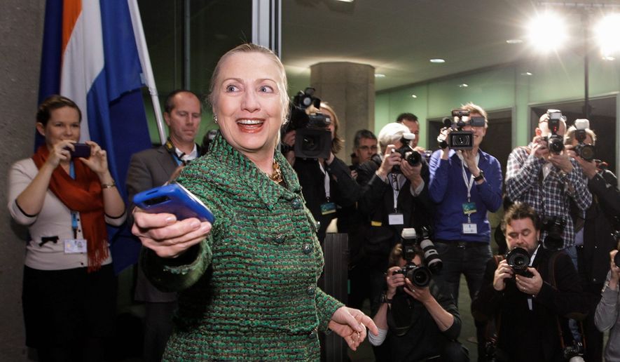 In a photo from Thursday, Dec. 8, 2011, then-U.S. Secretary of State Hillary Rodham Clinton hands off her mobile phone after arriving to meet with Dutch Foreign Minister Uri Rosenthal at the Ministry of Foreign Affairs in The Hague, Netherlands. Clinton urged the State Department to release the emails she wrote from a private email account as secretary of state, weighing in on a controversy that has generated negative attention this week for the likely Democratic presidential candidate. She still hasn&#39;t explained why she used her own email server and eschewed a State Department email address. (AP Photo/J. Scott Applewhite, Pool/File) (credit)
