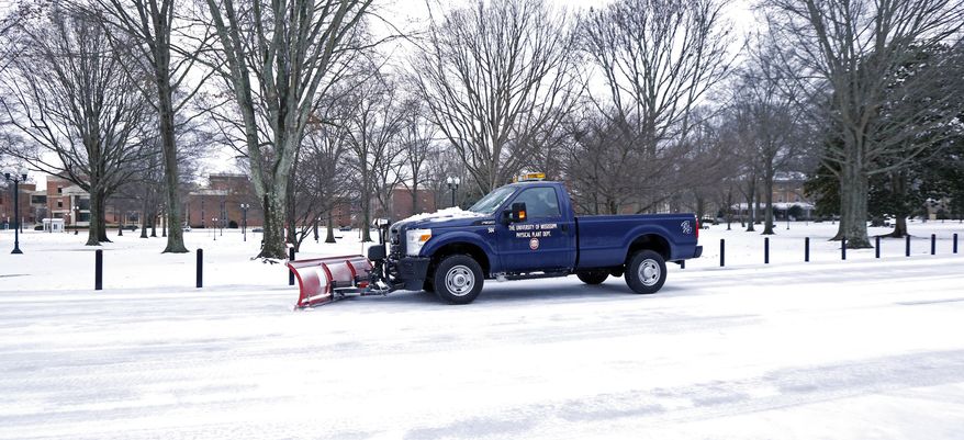 A snowplow moves down a street at the University of Mississippi in Oxford, Miss., as it drives past The Grove, Thursday, March 5, 2015. Sleet and snow continued Thursday morning across a wide belt of Mississippi, even as precipitation ended in the northwest part of the state. (AP Photo/Rogelio V. Solis)