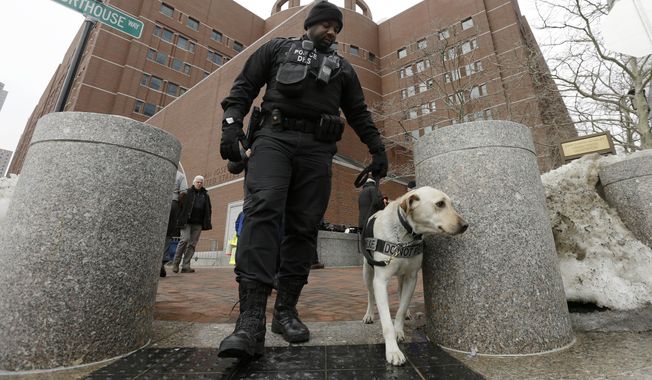 A federal police officer patrols with a security dog outside federal court, Wednesday, March 4, 2015, in Boston, on the first day of the federal death penalty trial of Boston Marathon bombing suspect Dzhokhar Tsarnaev. Tsarnaev is charged with conspiring with his brother to place two bombs near the marathon finish line in April 2013, killing three and injuring 260 people. (AP Photo/Steven Senne)