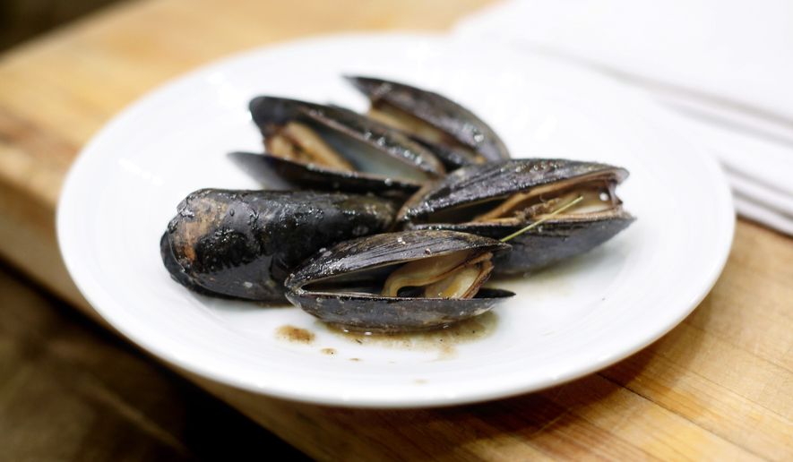 A dish of mussels roasted with pine needles is displayed during a cooking demonstration at the both annual Maine Fishermen's Forum, Thursday, March 5, 2015, in Rockport, Maine. Maine fishermen set a state record with a catch valued at more than $585 million in 2014. (AP Photo/Robert F. Bukaty)