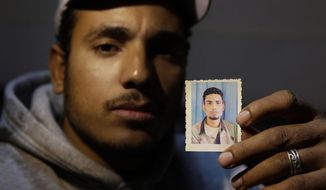 In this Wednesday, Feb. 25, 2015 photo, Ragab Farghali, 28, holds the photo of his 30-year-old brother, Walid Farghali, who was killed by an Egyptian policeman, during an interview with the Associated Press in Cairo, Egypt.  A 30-year-old minibus driver, Walid Farghali was shot in the chest by a policeman on Feb. 1 after he tried to get away when asked for his driver’s license. (AP Photo/Hassan Ammar)