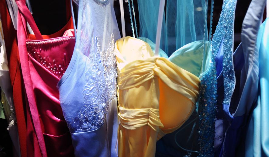 Donated prom dresses hang for sale at a $20 prom dress sale at Huron High School, in Ann Arbor, Mich., on Friday, April 25, 2014. The annual Prom Dress Project offers dresses for girls at an affordable price. (AP Photo/The Ann Arbor News, Brianne Bowen)