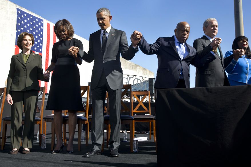 Former first lady Laura Bush, left, first lady Michelle Obama, President Barack Obama, Rep. John Lewis, D-Ga., former President George W. Bush, and Rep. Terri Sewell, D-Ala., hold hands during a prayer after the president&#x27;s speech by the Edmund Pettus Bridge in Selma, Ala., on the 50th anniversary of &amp;#8220;Bloody Sunday,&quot; a landmark event of the civil rights movement, Saturday, March 7, 2015. (AP Photo/Jacquelyn Martin)