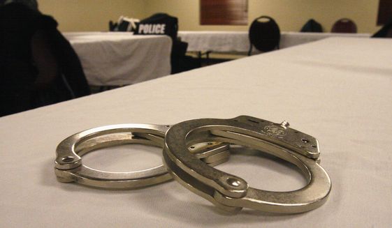 Handcuffs lay on a table in this file photo from March 2015. A First Amendment group is springing into action after reports that two UConn students were arrested essentially for having shouted racist epithets in public, a violation of their free speech rights, according to the Foundation for Individual Rights in Education. (AP Photo/Martha Irvine) **FILE**