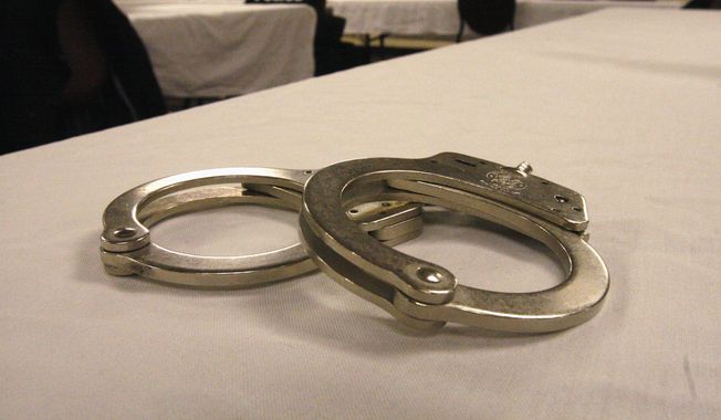 Handcuffs lay on a table in this file photo from March 2015. (AP Photo/Martha Irvine) **FILE**