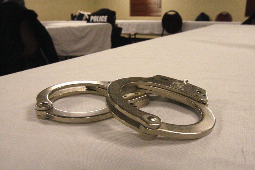 Handcuffs lay on a table in this file photo from March 2015. A First Amendment group is springing into action after reports that two UConn students were arrested essentially for having shouted racist epithets in public, a violation of their free speech rights, according to the Foundation for Individual Rights in Education. (AP Photo/Martha Irvine) **FILE**