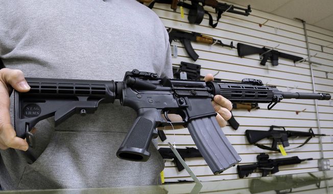 John Jackson, co-owner of Capitol City Arms Supply in Springfield, Illinois, shows off an AR-15 assault rifle. (Associated Press) **FILE**