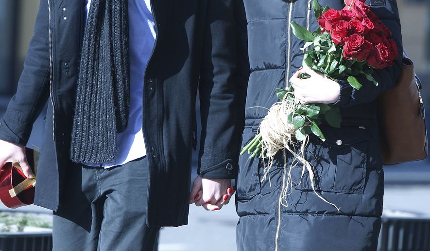Young people are walking with gifts for their loved ones in celebration of Valentine's Day in the center of Warsaw, Poland, Saturday, Feb. 14, 2015.(AP Photo/Czarek Sokolowski)