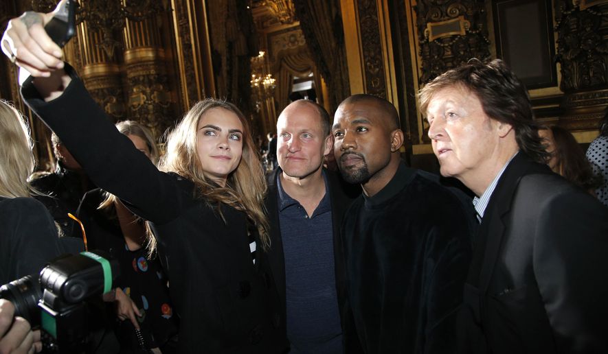 From left, model Cara Delevingne, takes a photographer with actor Woody Harrelson, singers Kanye West and Paul McCartney prior to Stella McCartney&#39;s ready to wear fall-winter 2015-2016 fashion collection during Paris Fashion Week, Paris, France, Monday, March 9, 2015. (AP Photo/Thibault Camus)