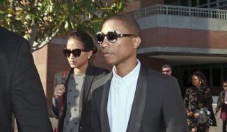 In this Wednesday, March 4, 2015, photo, Pharrell Williams and an unidentified woman leave Los Angeles Federal Court after testifying at trial in Los Angeles. A jury says singers Williams and Robin Thicke copied a Marvin Gaye song to create &amp;quot;Blurred Lines&amp;quot; and awarded more than $7 million to Gaye&#39;s family. (AP Photo/Nick Ut, File) **FILE**
