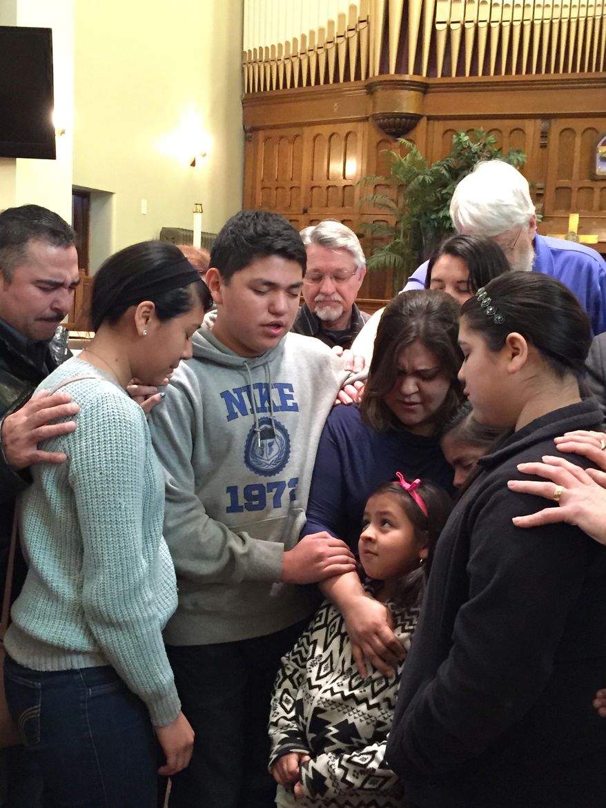 Gloria Villatoro joins her children, friends and community members in prayer at the Trinity United Methodist Church in Des Moines, Iowa, Tuesday, March 10, 2015. Villatoro was traveling to the Omaha Immigration and Customs Enforcement office to deliver 25,518 petitions, calling for the release of her husband, Max Villatoro, who was arrested by immigration officials last week and now faces deportation for a 17-year-old drunken driving conviction. (AP Photo/Kourtney Liepelt)