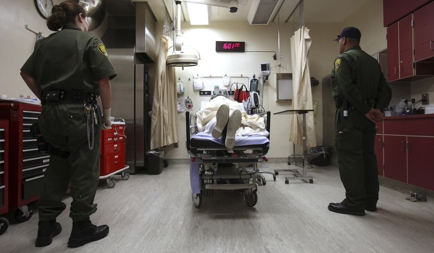 FILE - In this Jan. 14, 2009, file photo, correctional officers stand watch over an inmate receiving treatment in the emergency room at California State Prison, Corcoran, in Corcoran, Calif. U.S. District Court Judge Thelton Henderson has outlined a plan for California to end nearly a decade of federal control of its prison health care system, Tuesday, March 10, 2015. (AP Photo/Rich Pedroncelli, File)