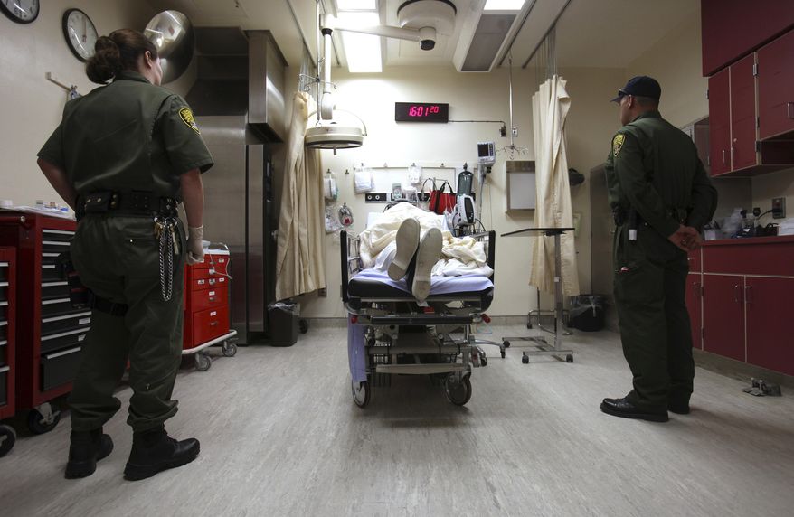 FILE - In this Jan. 14, 2009, file photo, correctional officers stand watch over an inmate receiving treatment in the emergency room at California State Prison, Corcoran, in Corcoran, Calif. U.S. District Court Judge Thelton Henderson has outlined a plan for California to end nearly a decade of federal control of its prison health care system, Tuesday, March 10, 2015. (AP Photo/Rich Pedroncelli, File)