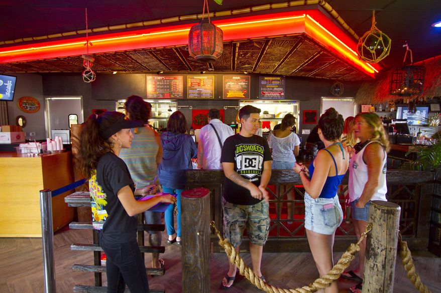 ADVANCE FOR SUNDAY MARCH 15 AND THEREAFTER In this photo taken Feb. 25, 2015, people gather at Teddy's Bigger Burger new location in Haleiwa, Hawaii. The Tiki-themed spot has a bar and is part of Kamehameha Schools’ latest retail project, the 27,000-square-foot Haleiwa Store Lots. The plantation-inspired retail, dining and cultural gathering place is only 60 percent complete, but already it has become a must-see stop in the historic North Shore beach town where 2.5 million tourists come through annually. (AP Photo/Honolulu Star-Advertiser, Dennis Oda)