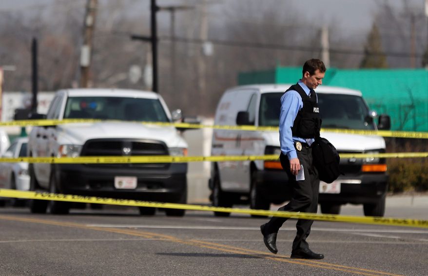 Ferguson County police officers went to work Thursday after the resignation of the department's chief and after two officers were injured by gunfire outside the station during a protest. New Police Chief Jon Belmar called the attack on the officers an "ambush." (Associated Press photographs)