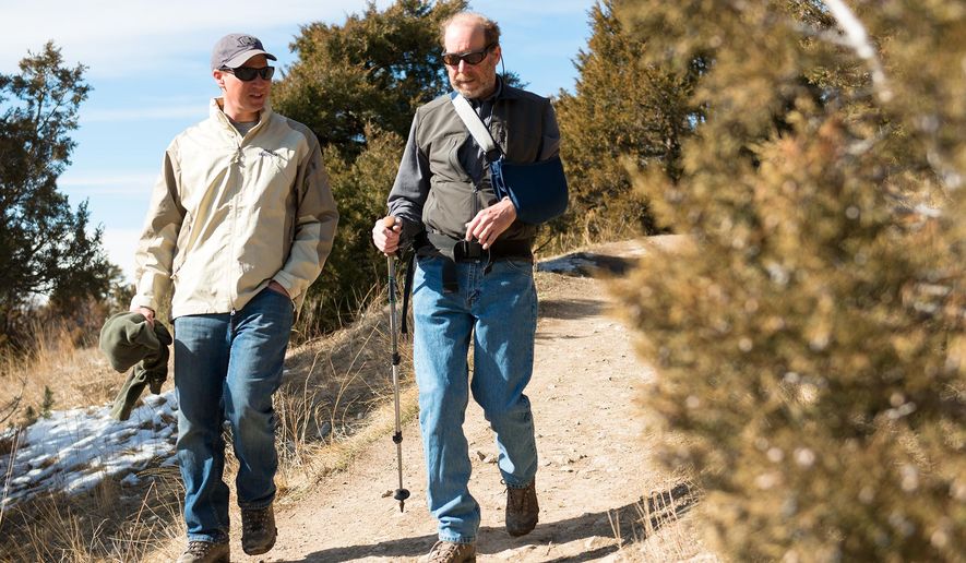 Trail Ambassador Jeremy Kunzman, left, speaks with hiker John Banta, of Bozeman, about community trails as they walk the College ‘M’ trail in Bozeman, Mont., Monday, March 9, 2015. In response to graffiti and other trail abuses, the Gallatin Valley Land Trust, U.S. Forest Service, Friends of Hyalite and Bridger Ski Foundation have teamed up to launch a Trail Ambassador Program.(AP Photo/Bozeman Chronicle, Ben Pierce)