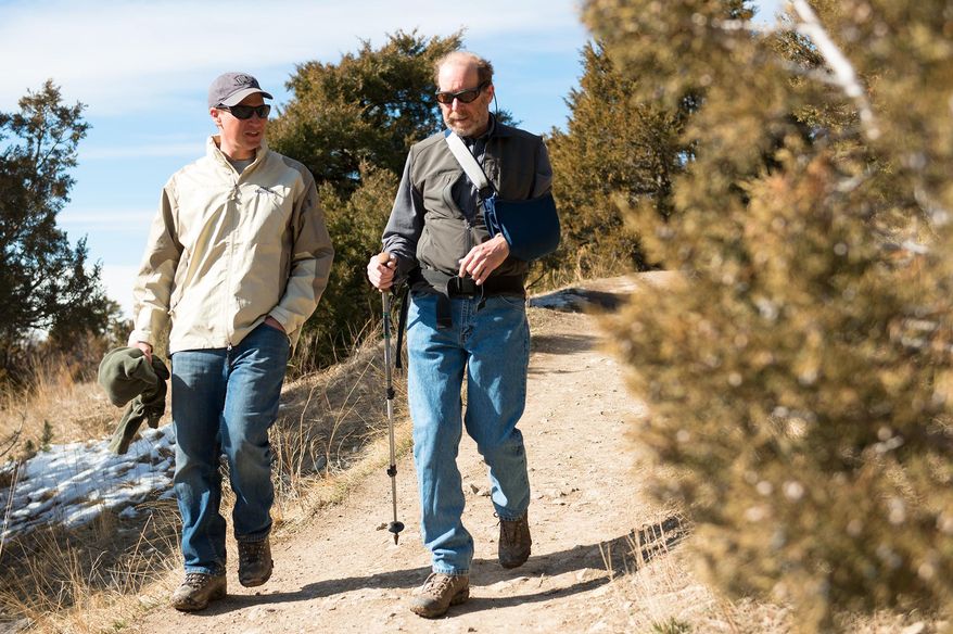 Trail Ambassador Jeremy Kunzman, left, speaks with hiker John Banta, of Bozeman, about community trails as they walk the College ‘M’ trail in Bozeman, Mont., Monday, March 9, 2015. In response to graffiti and other trail abuses, the Gallatin Valley Land Trust, U.S. Forest Service, Friends of Hyalite and Bridger Ski Foundation have teamed up to launch a Trail Ambassador Program.(AP Photo/Bozeman Chronicle, Ben Pierce)