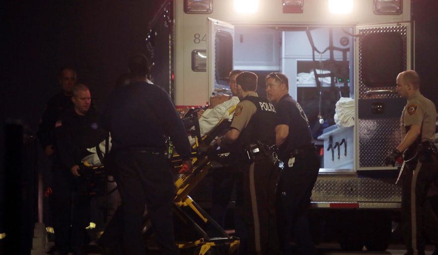 Paramedics load one of two police officers who were shot while standing guard in front of the Ferguson Police Station during a protest on Thursday, March 12, 2015.  A 32-year-old officer from nearby Webster Groves was shot in the face and a 41-year-old officer from St. Louis County was shot in the shoulder, St. Louis County Police Chief Jon Belmar said at a news conference. Both were taken to a hospital, where Belmar said they were conscious. (AP Photo/St. Louis Post-Dispatch, Laurie Skrivan)  EDWARDSVILLE INTELLIGENCER OUT; THE ALTON TELEGRAPH OUT