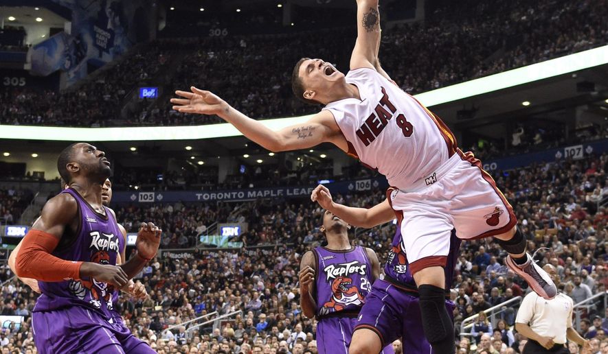 Miami Heat guard Tyler Johnson (8) is fouled by Toronto Raptors&#39; Greivis Vasquez during second-half NBA basketball game action in Toronto, Friday, March 13, 2015. (AP Photo/The Canadian Press, Frank Gunn)