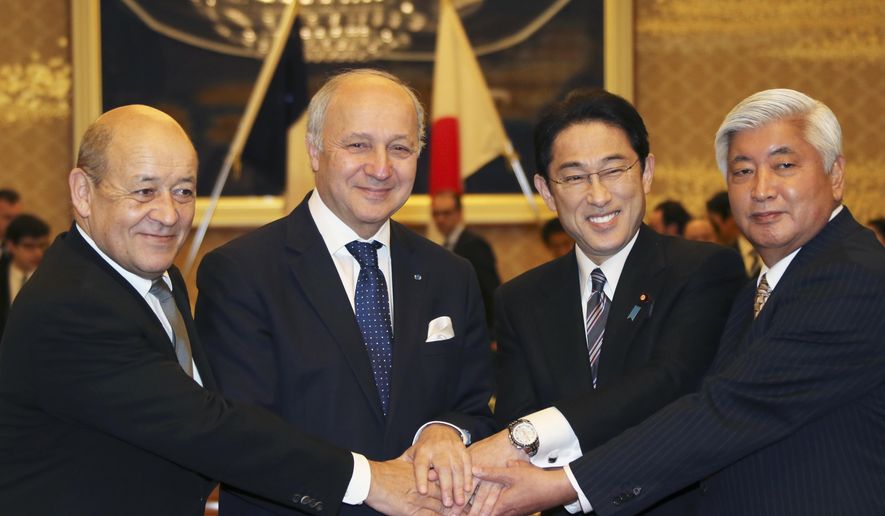 French Defense Minister Jean-Yves Le Drian, left, and French Foreign Minister Laurent Fabius, second left, join hands with Japanese Foreign Minister Fumio Kishida, seond right, and Japanese Defense Minister Gen Nakatani during a Japan-France two-plus-two meeting in Tokyo, Friday, March 13, 2015. Japan and France signed an arms transfer agreement Friday, paving the way for developing drones and other unmanned equipment together as Japan seeks to play a greater military role internationally. (AP Photo/Koji Sasahara,pool)