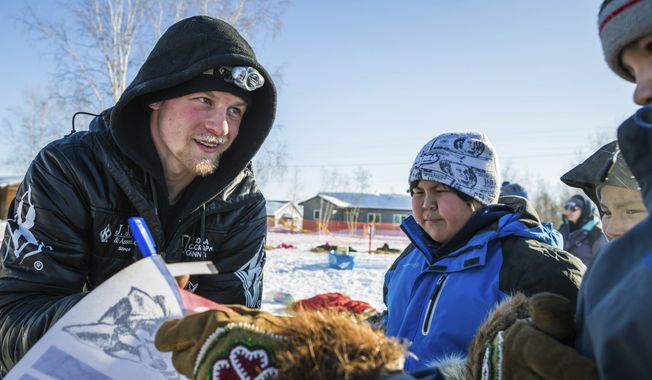 Dallas Seavey signs autographs at the Huslia, Alaska, checkpoint of the Iditarod Trail Sled Dog Race, Friday, March 13, 2015. (AP Photo/Alaska Dispatch News, Loren Holmes)