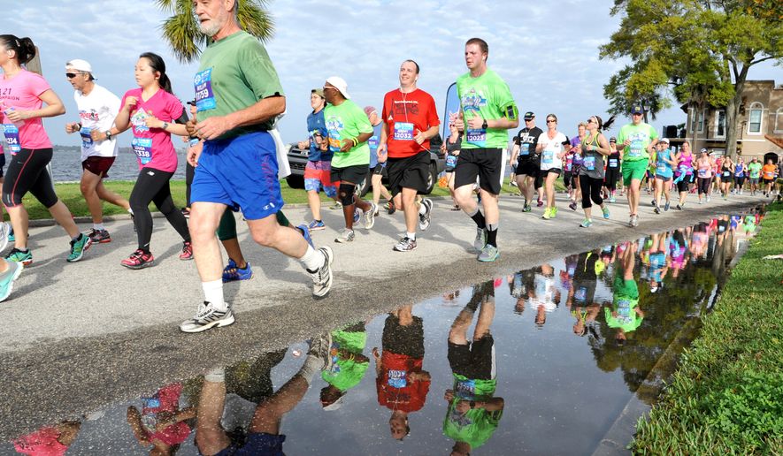 Runners reflect in water after just passing the 5k distance on River Road during the 38th Gate River Run 15k road race on Saturday March 14, 2015 in Jacksonville, Fla. (AP Photo/Florida Times-Union,Bruce Lipsky)