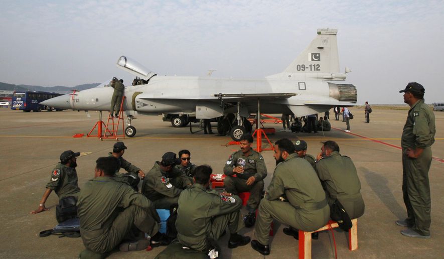 FILE - In this Nov. 21, 2010, file photo, Pakistan Air Force personnel sit in front of their JF-17 jet fighter at the 8th China International Aviation and Aerospace Exhibition (Zhuhai Airshow) in Zhuhai, southern coast of Guangdong province, China.  China has overtaken Germany to become the world’s third-biggest arms exporter, although its 5 percent of the market remains small compared to the combined 58 percent of exports from the U.S. and Russia, a new study says. (AP Photo/Kin Cheung, File)