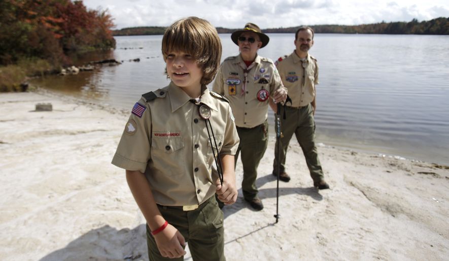 In this Oct. 3, 2009 photo, Tenderfoot Scout Bradley Corr, 11, left, his father Warren Corr, Troop 29 committee member, right, and his grandfather Ted Corr, who is Unit Commissioner with the Forks of the Delaware district of the Minis Trails Council walk along the shore of Stillwater Lake at Boy Scout camp at Camp Minsi in Pocono Summit, Pa. As the Boy Scouts of America heads toward its 100th anniversary in February, its first century adds up to a remarkable saga, full of achievement, complexity and contradiction. On one hand, no other U.S. youth organization has served as many boys, an estimated 112 million over the years. On the other hand, in both the courts and the public arena, the BSA has doggedly defended its right to discriminate, excluding gays and atheists from its ranks, and overriding requests from some local units to soften those policies. (AP Photo/Carolyn Kaster)