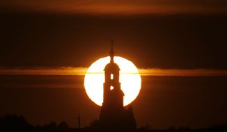An Orthodox church is silhouetted during sunset in the village of Mozoli, 30 miles northwest of the capital,  Minsk, Belarus, Monday, March 16, 2015. (AP Photo/Sergei Grits)