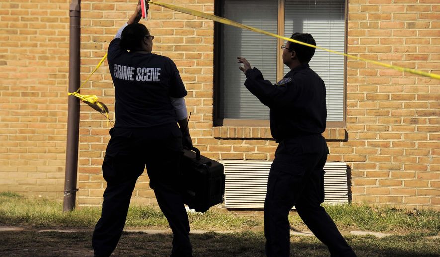 Crime scene investigators step beneath police tape to document the scene and gather evidence where a stabbing took place at Morgan State University, Tuesday, March 17, 2015, in Baltimore. Two groups of people got into a fight outside a dining hall on the Morgan State University campus, and some football players were stabbed by someone swinging a knife wildly, police and college officials said. (AP Photo/The Baltimore Sun, Karl Merton Ferron)