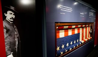 A large photograph depicting President Abraham Lincoln&#39;s assassin John Wilkes Booth is displayed next to the bunting flag hung from the presidential box at the historic Ford&#39;s Theatre at a new exhibit entitled &amp;quot;Silent Witnesses: Artifacts of the Lincoln Assassination&amp;quot; Tuesday, March 17, 2015, at the Ford&#39;s Center for Education and Leadership in Washington. (AP Photo/Andrew Harnik) ** FILE **