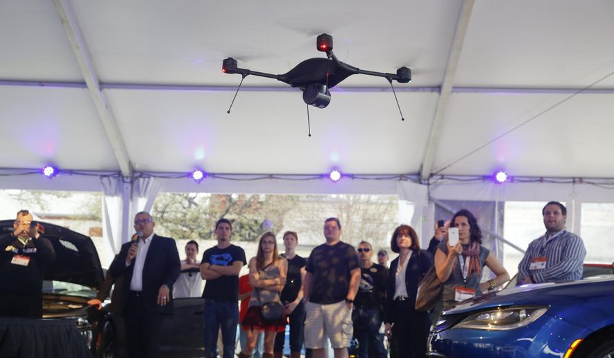 In this March 14, 2015, file photo, a crowd observes an Indago drone demonstration during the "Tech Chat: How Drones Can Aid Transportation" at the C3 Group's Connected Car Pavilion during the SXSW Interactive Festival in Austin, Texas. The Indago can be equipped with a thermal camera, has a 45-minute capacity battery, auto-pilot features, a range over 5 line-of-sight miles, and can carry a payload of up to one pound. (AP Photo/Jack Plunkett, File)