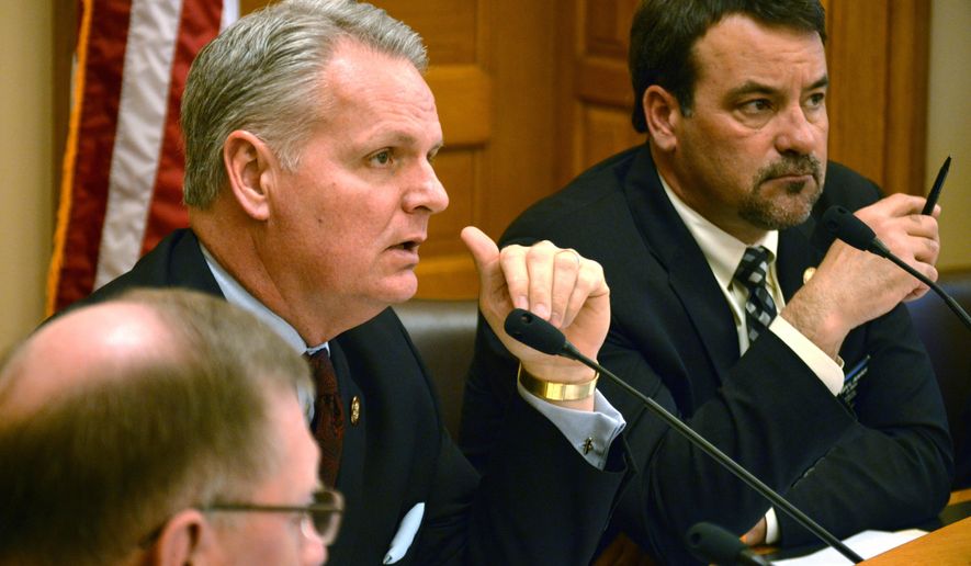 Kansas state Rep. Marc Rhoades, left, asks a question during a House committee hearing on a proposal to require the state pension system to divest from companies with interests in Iran, Wednesday, March 18, 2015, at the Statehouse in Topeka, Kan. Sitting to his right is Rep. Kent Thompson, an Iola Republican. (AP Photo/Nicholas Clayton)