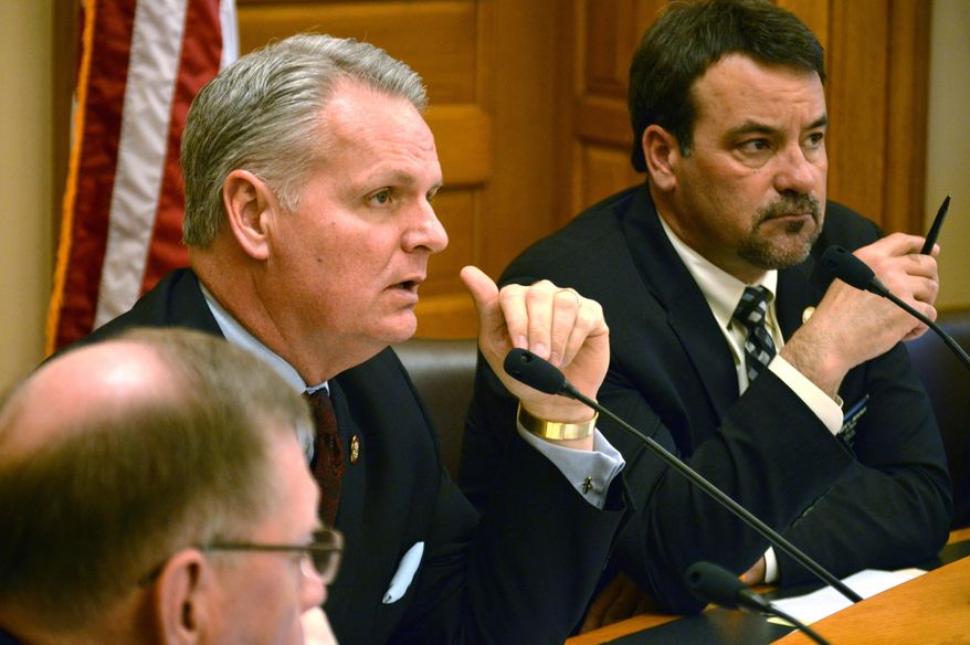 Kansas state Rep. Marc Rhoades, left, asks a question during a House committee hearing on a proposal to require the state pension system to divest from companies with interests in Iran, Wednesday, March 18, 2015, at the Statehouse in Topeka, Kan. Sitting to his right is Rep. Kent Thompson, an Iola Republican. (AP Photo/Nicholas Clayton)