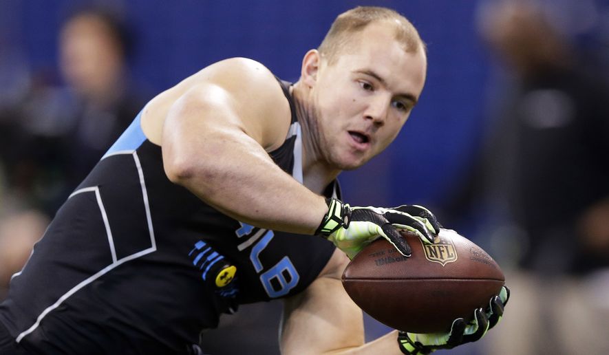 FILE - In this Feb. 24, 2014 file photo, Wisconsin linebacker Chris Borland makes a catch as he runs a drill at the NFL football scouting combine in Indianapolis. Borland is one of the most heralded linebackers to come out of Wisconsin, but questions remain about how his skills might carry over to the NFL. (AP Photo/Michael Conroy, File)