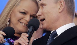 Russian President Vladimir Putin and singer Larisa Dolina sing the national anthem at a rally marking the one year anniversary of annexation of Ukraine&#x27;s Crimea peninsula, outside the Kremlin in  Moscow, Russia, Wednesday, March 18, 2015. Speaking to tens of thousands of supporters just outside the Kremlin walls, President Vladimir Putin has described Russia&#x27;s annexation of Ukraine&#x27;s Crimean Peninsula as a move to protect ethnic Russians and regain the nation&#x27;s &quot;historic roots.&quot; (AP Photo/Maxim Shipenkov, Pool)